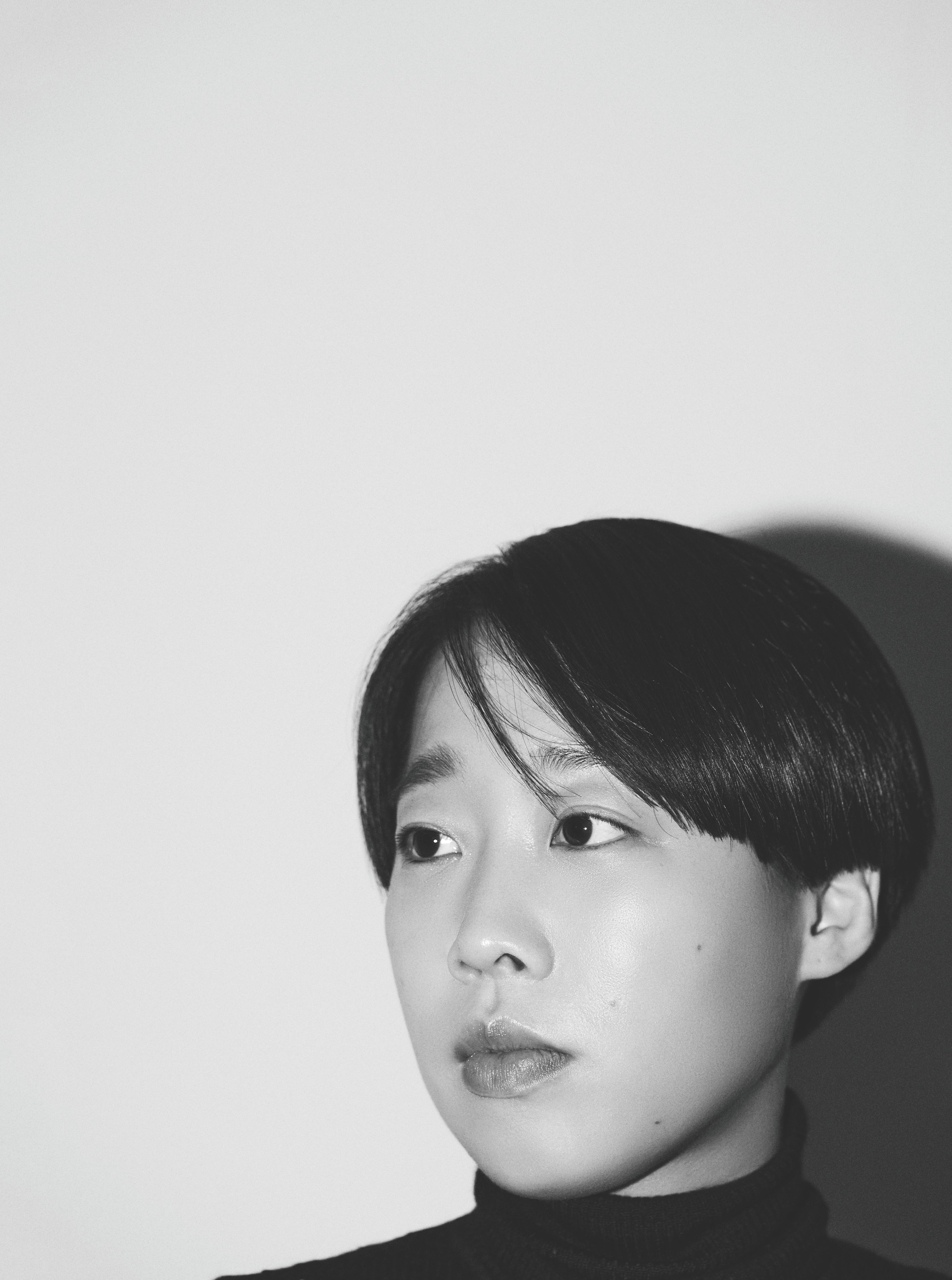 In a black-and-white photo, the black-haired, short-cut director is looking to the left.