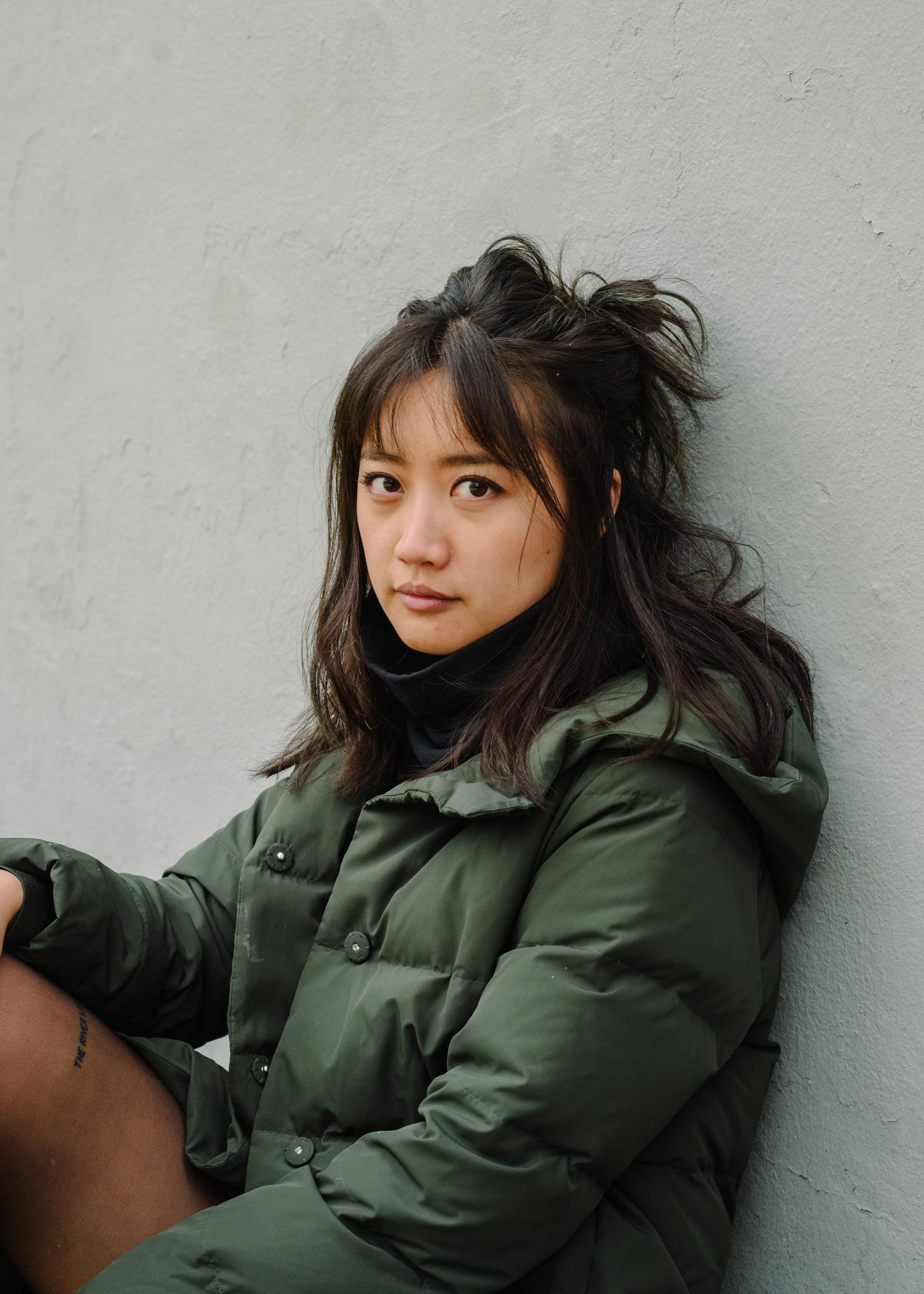 Ash Goh Hua looking straight ahead. She has shoulder-length dark hair partially tied up in a bun.