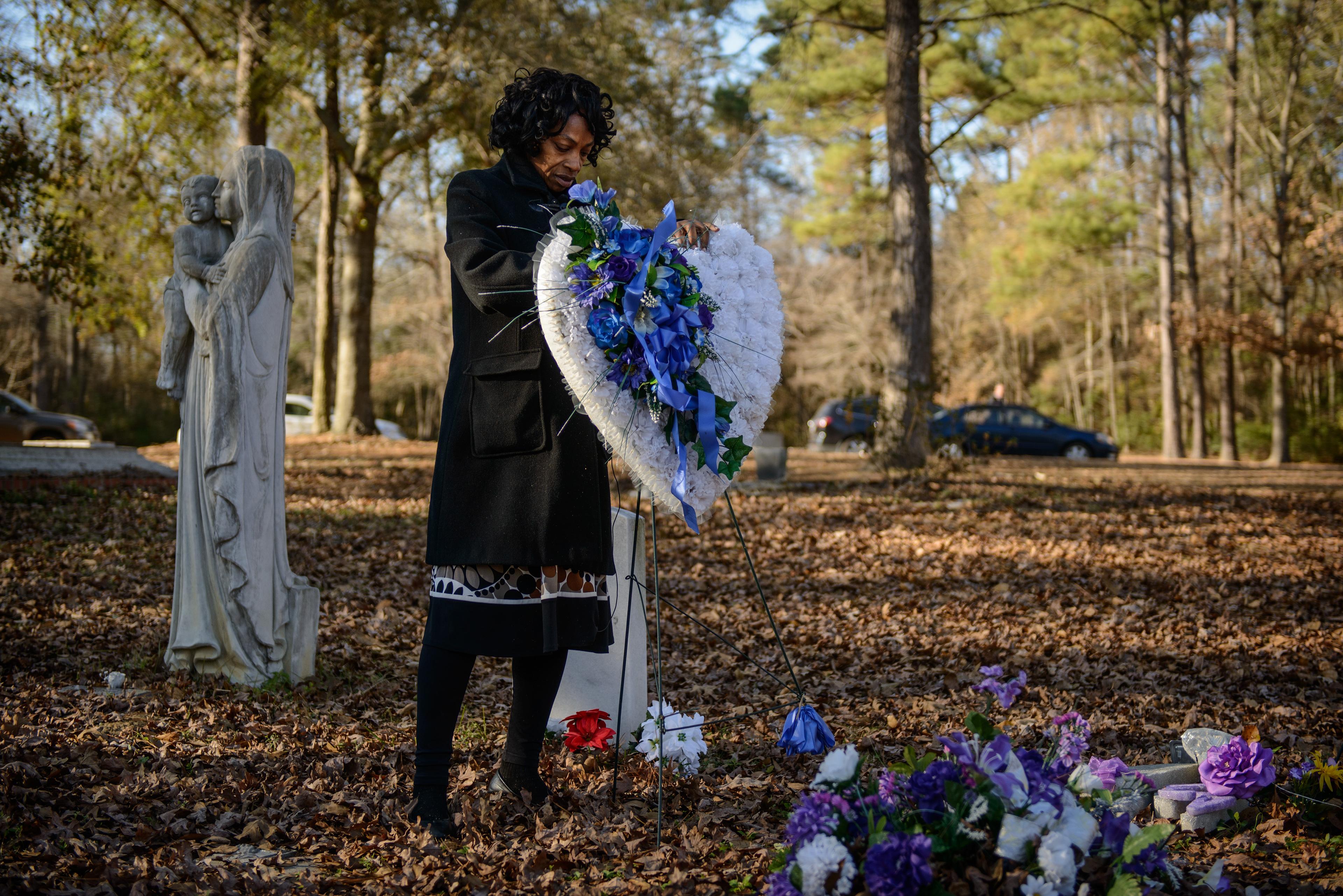 Still from Always In Season. Claudia Lacy cleans up the flowers at the grave of her son, Lennon Lacy, Sunday, Dec. 14, 2014, at Old Shaw-Lacy Field Cemetery in Bladenboro, N.C. Lennon Lacy, a 17-year-old black teenager, was found dead on Aug. 29, 2014, hanging from a swing set in a trailer park in the rural community. Police ruled the death a suicide, but his family believe it was murder.