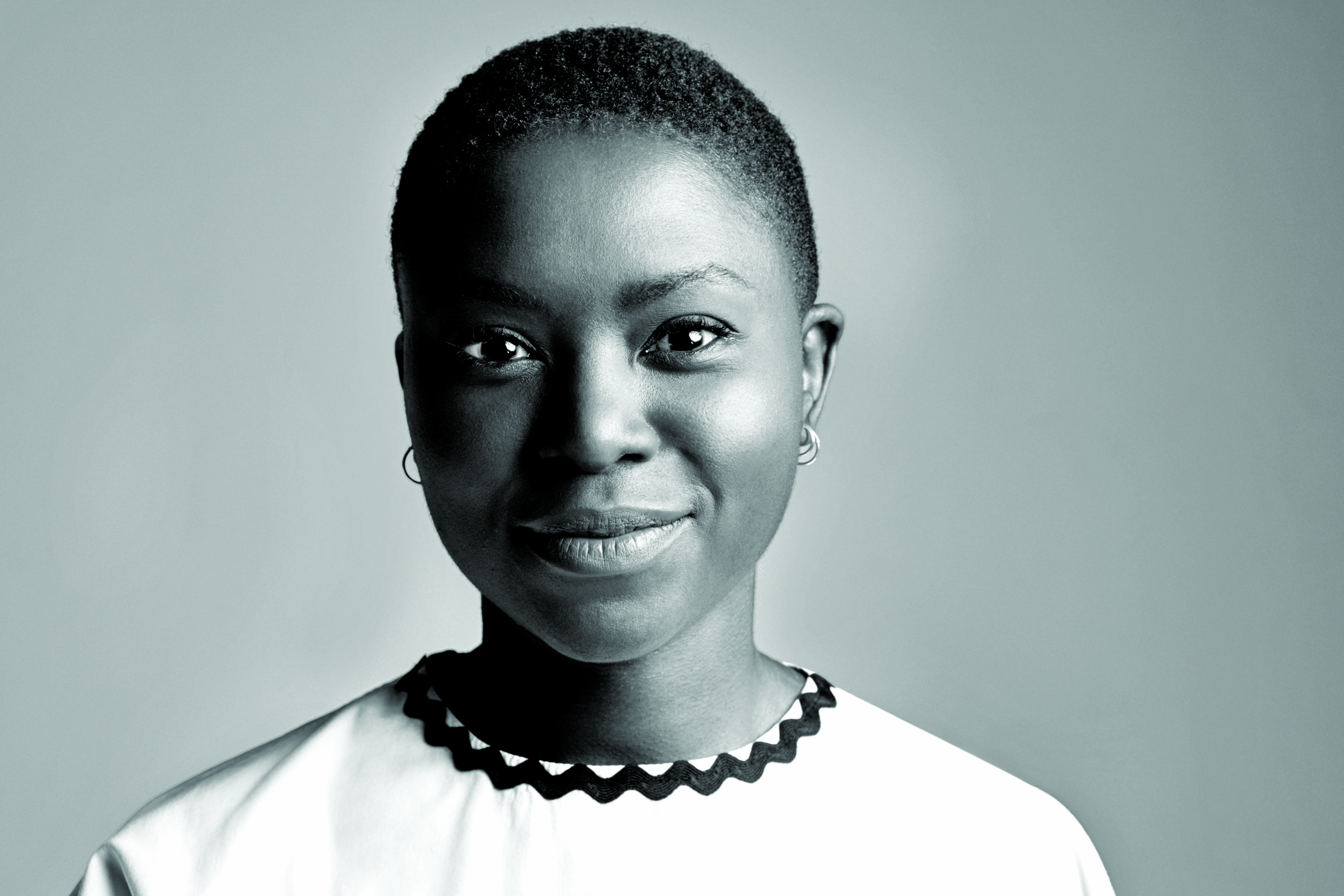 Milisuthando Bongela is looking at the camera, smiling. Black and white portrait.